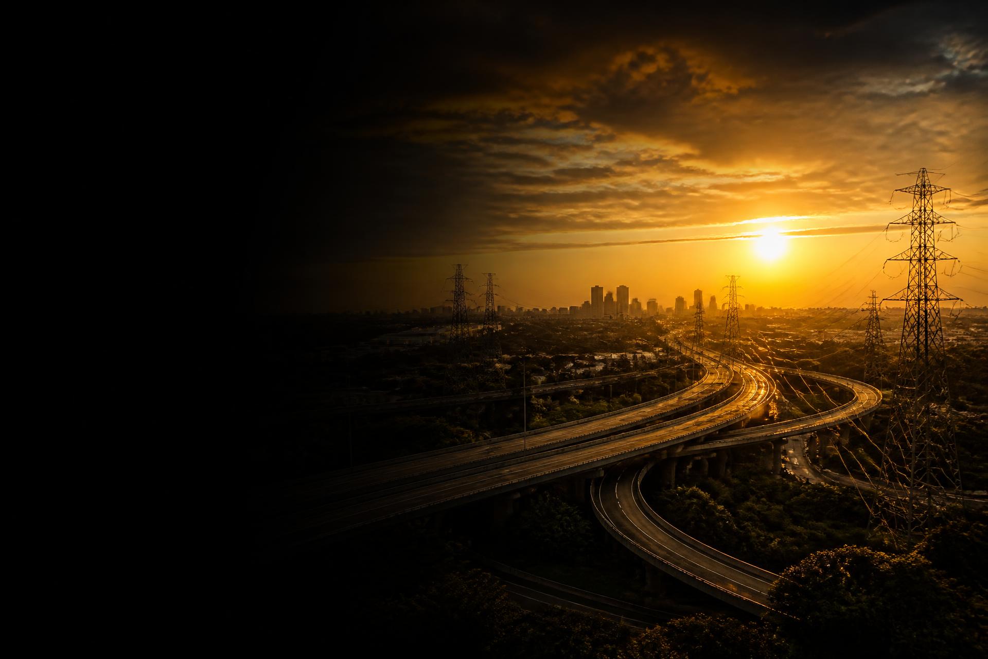 Infrastructure at golden hour — highways, transmission towers and skyline